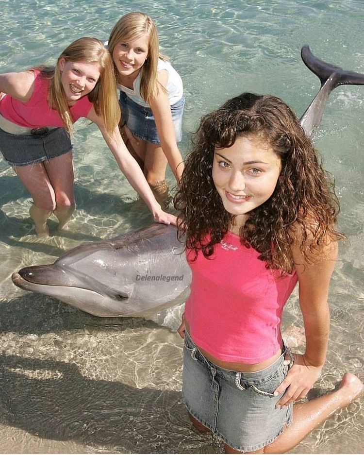 three girls in the water with a dolphin, giving mermaid-summer energy